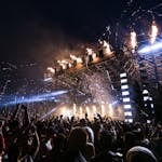 Vibrant concert scene with crowd enjoying night festival and dynamic stage fireworks.